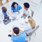 physicians huddled together at a table