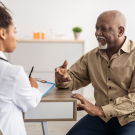 Older man speaking with physician 