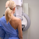 woman standing in a mammogram machine