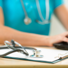 physician with chart and stethoscope