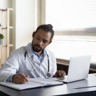 Taking-notes-next-to-laptop-zoom-out